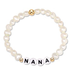 A beaded stretch bracelet featuring white baroque pearls, two gold-toned spacer beads, and four white round beads spelling 'NANA' in black lettering, set against a plain white background.