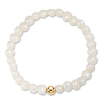 A beaded stretch bracelet made of white freshwater pearls with a single polished gold accent bead at the bottom center, shown on a plain white background.